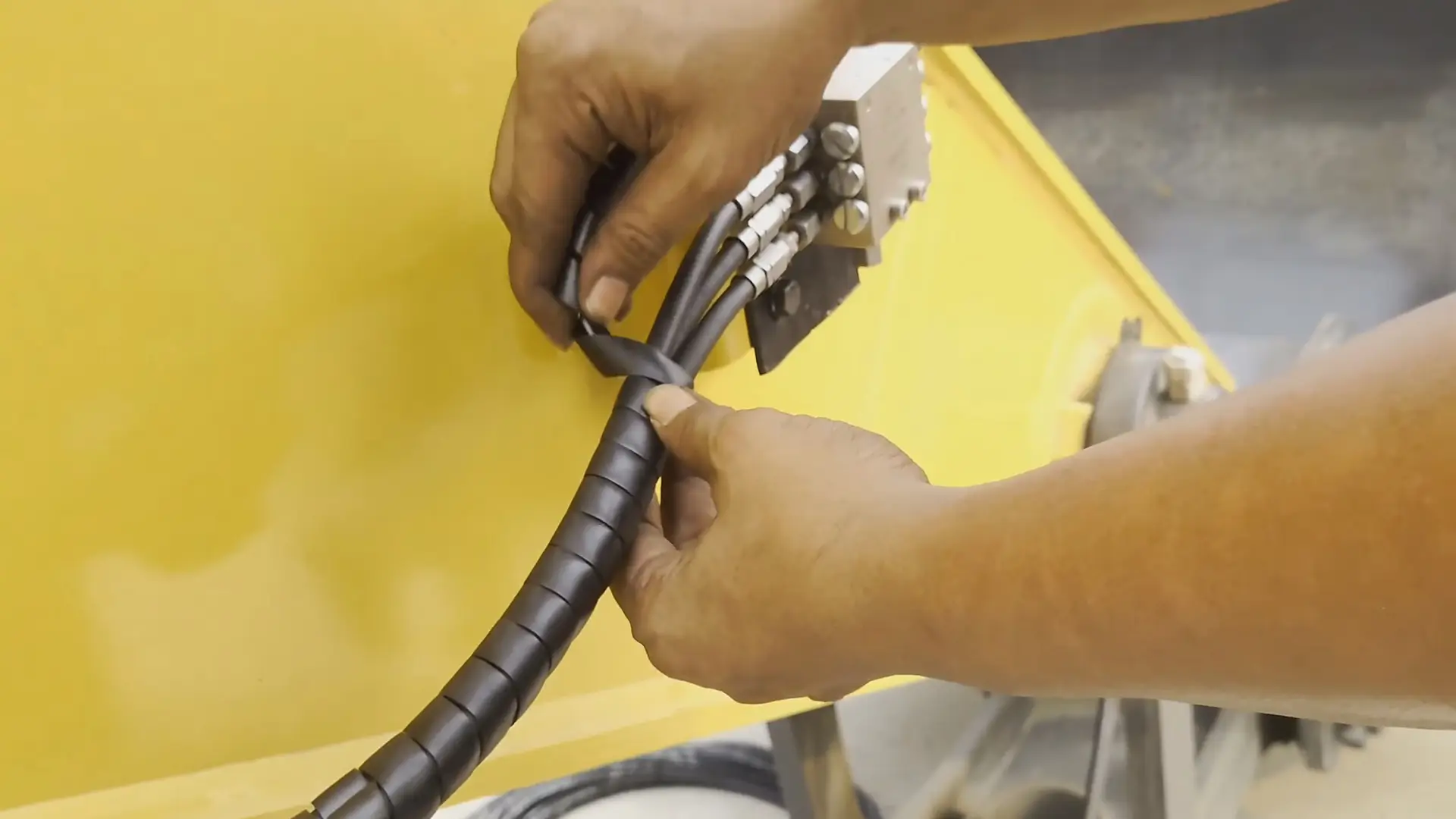 Dokumentasi routing hose dengan pelindung spiral pada instalasi excavator
